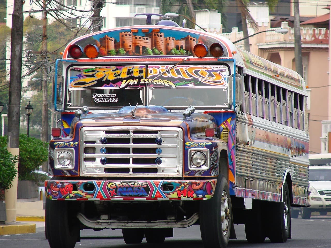 Un autobús de pasajeros pintado con colores vivos en una calle de la ciudad.