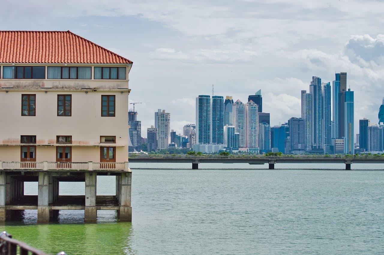 Un edificio histórico junto al agua y rascacielos modernos en la orilla opuesta de Ciudad de Panamá.